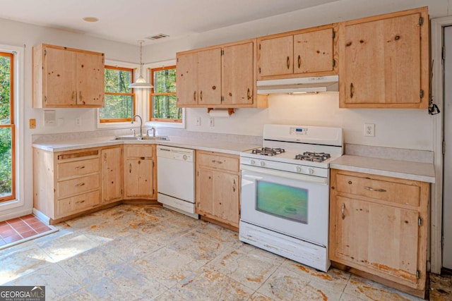 kitchen featuring white appliances, hanging light fixtures, sink, and light brown cabinetry