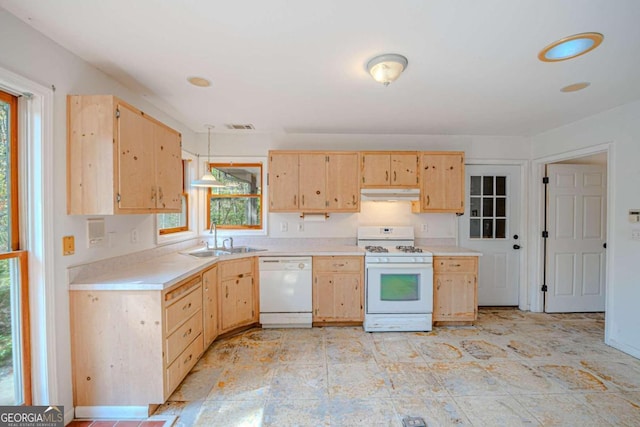 kitchen featuring white appliances, hanging light fixtures, light brown cabinets, and sink