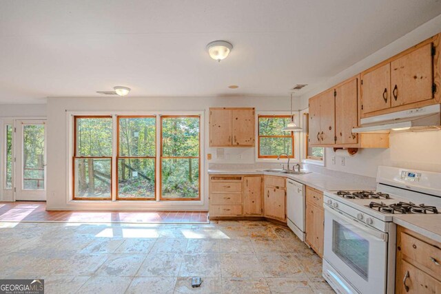 kitchen with sink, white appliances, decorative light fixtures, and light brown cabinets