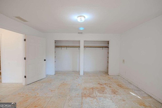 unfurnished bedroom featuring two closets