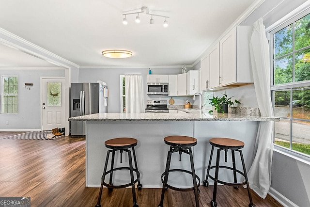 kitchen with plenty of natural light, appliances with stainless steel finishes, and white cabinetry