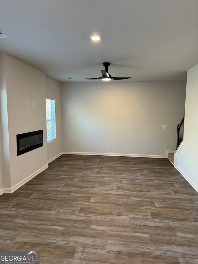 unfurnished living room with ceiling fan and dark hardwood / wood-style flooring