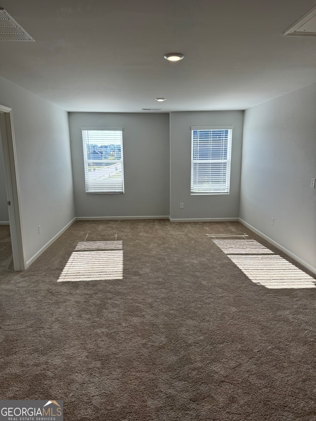 spare room featuring dark colored carpet