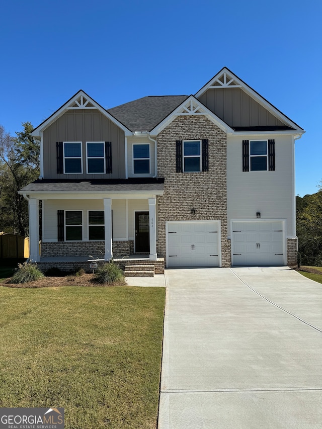 view of front of home with a front yard, a garage, and covered porch