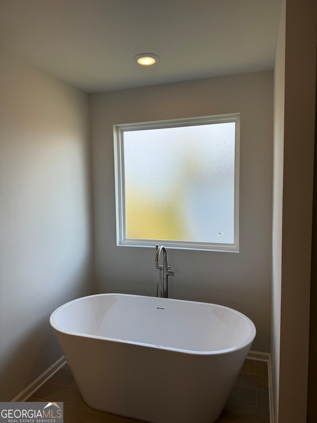 bathroom with tile patterned floors and a bathing tub