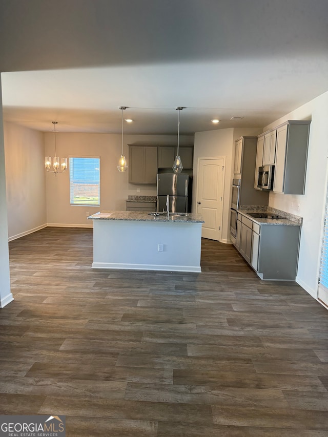 kitchen featuring a center island with sink, appliances with stainless steel finishes, dark hardwood / wood-style floors, and gray cabinetry