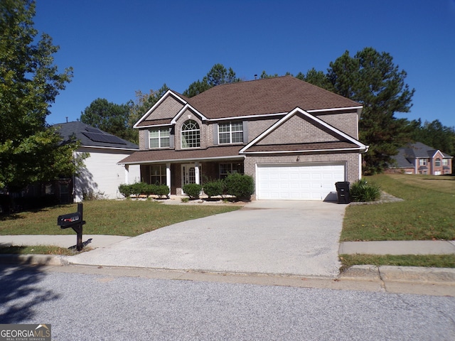 view of front facade featuring a garage, a front lawn, and a porch