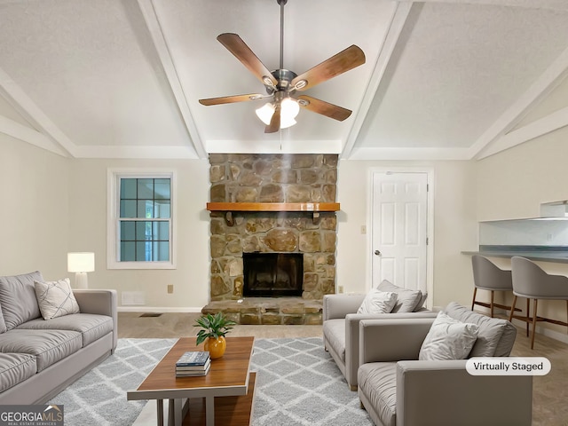 living room with ceiling fan, vaulted ceiling with beams, and a stone fireplace