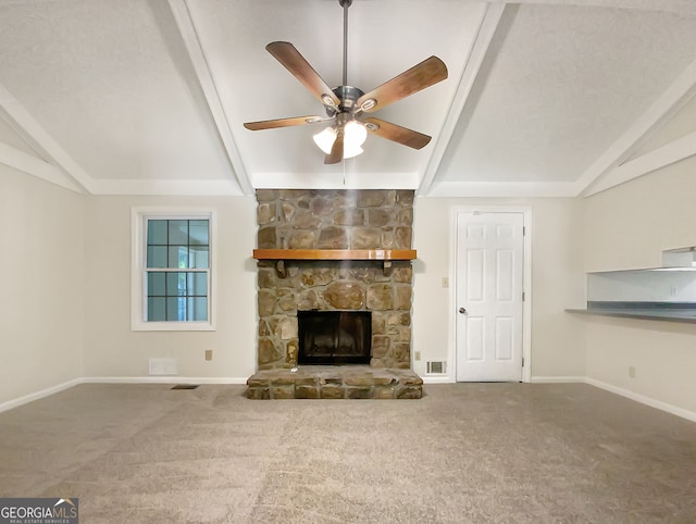 unfurnished living room with carpet floors, a stone fireplace, and vaulted ceiling with beams