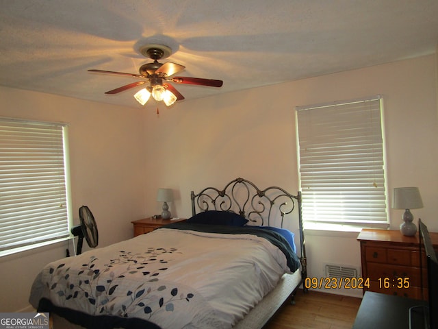 bedroom with ceiling fan and hardwood / wood-style flooring