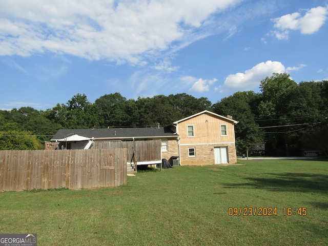 rear view of house featuring a yard