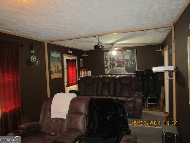 cinema with ornamental molding, ceiling fan, and a textured ceiling