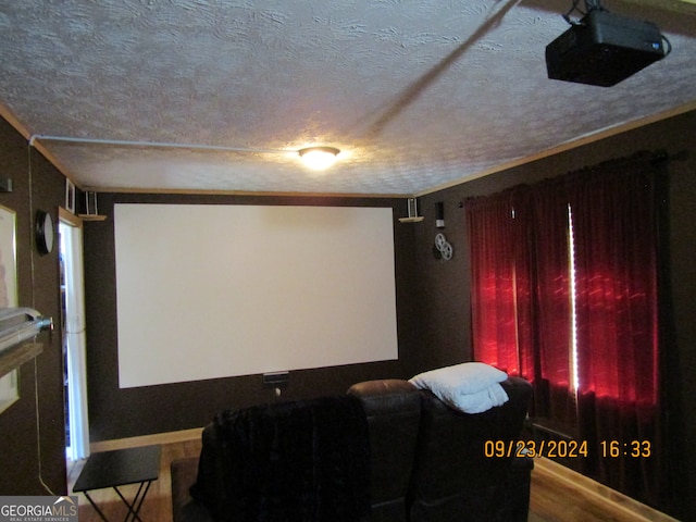 home theater room with ornamental molding and a textured ceiling