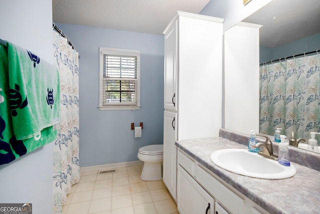 bathroom featuring toilet, vanity, a textured ceiling, and tile patterned flooring