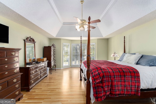 bedroom with access to outside, ceiling fan, light hardwood / wood-style flooring, and a tray ceiling