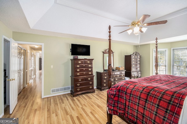 bedroom with a textured ceiling, ceiling fan, and light hardwood / wood-style flooring