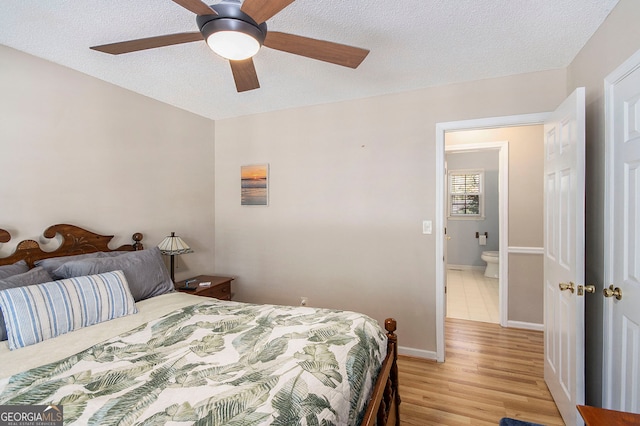 bedroom with light hardwood / wood-style floors, ceiling fan, and a textured ceiling