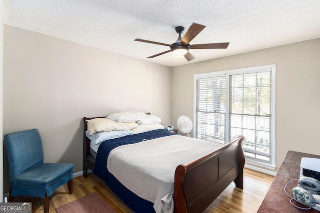 bedroom featuring a textured ceiling, light hardwood / wood-style floors, and ceiling fan