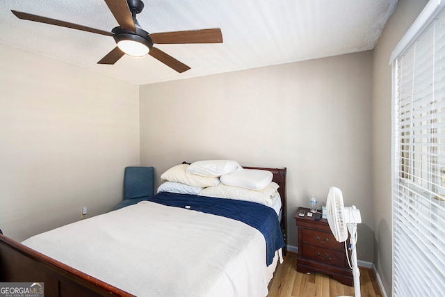 bedroom featuring ceiling fan, a textured ceiling, and light hardwood / wood-style flooring