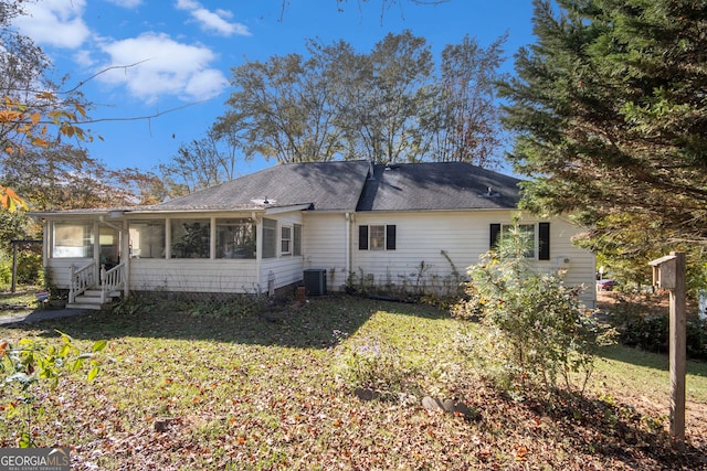 back of property featuring central AC unit, a sunroom, and a yard