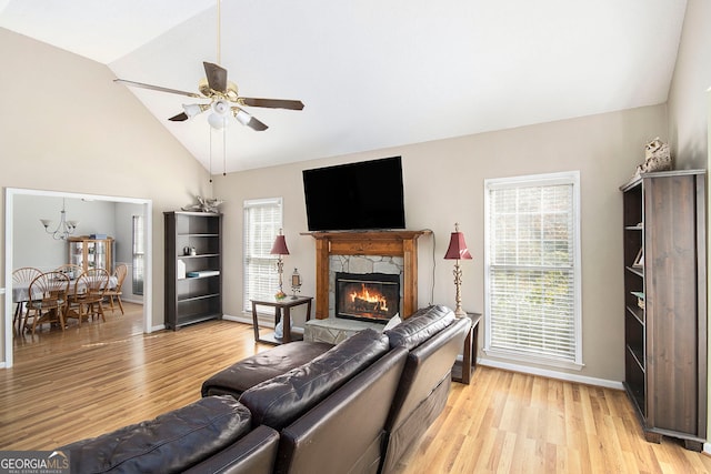 living room with light hardwood / wood-style floors, ceiling fan, a healthy amount of sunlight, and a high end fireplace