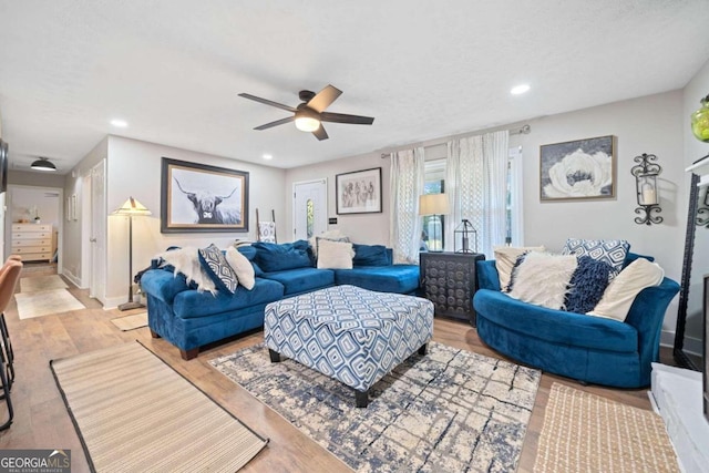 living room featuring light wood-type flooring and ceiling fan