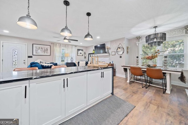 kitchen with plenty of natural light, white cabinetry, and decorative light fixtures