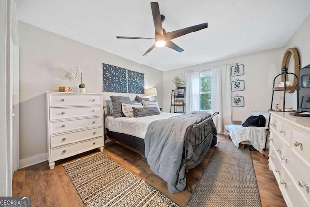 bedroom with dark hardwood / wood-style flooring and ceiling fan