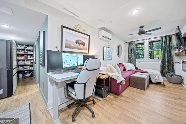 office featuring ceiling fan, light hardwood / wood-style floors, and an AC wall unit