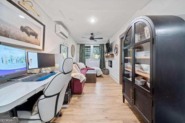 office space with light hardwood / wood-style floors, a wall mounted air conditioner, and ceiling fan