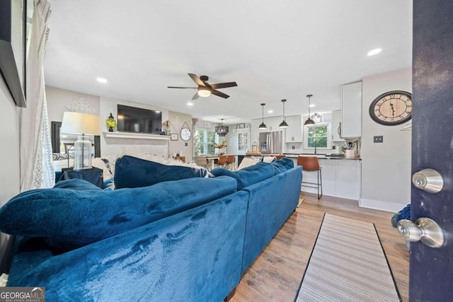 living room featuring ceiling fan and light hardwood / wood-style floors