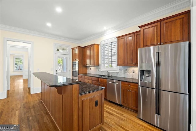 kitchen featuring plenty of natural light, light hardwood / wood-style floors, appliances with stainless steel finishes, and a center island