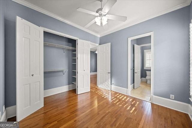 unfurnished bedroom with ceiling fan, connected bathroom, ornamental molding, a closet, and light hardwood / wood-style floors