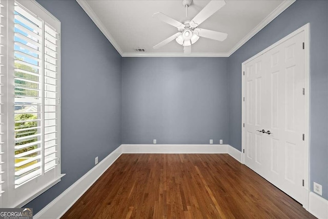 unfurnished bedroom featuring multiple windows, ceiling fan, dark hardwood / wood-style floors, and crown molding