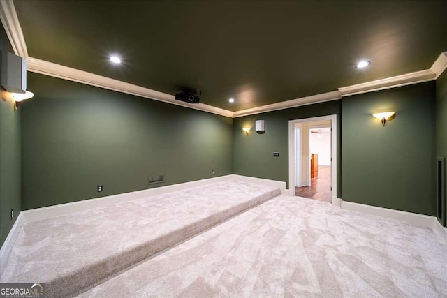 carpeted home theater featuring ornamental molding