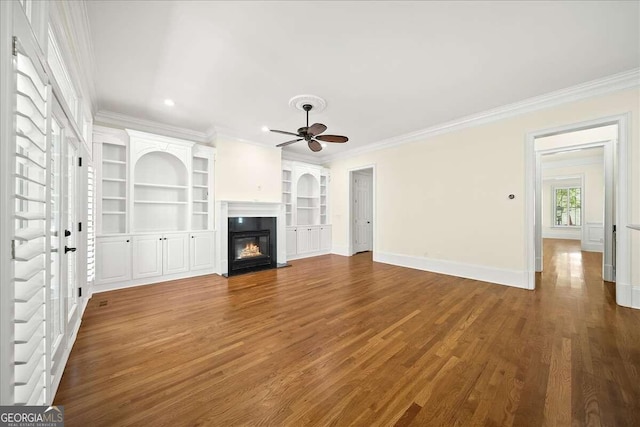 unfurnished living room featuring ceiling fan, hardwood / wood-style flooring, crown molding, and built in features