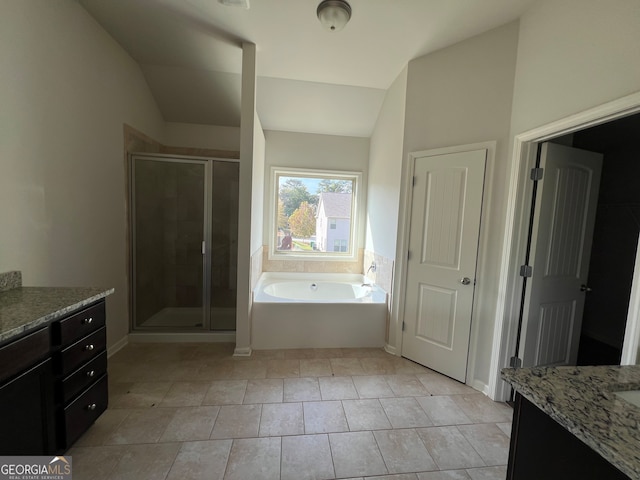 bathroom with shower with separate bathtub, vanity, vaulted ceiling, and tile patterned flooring