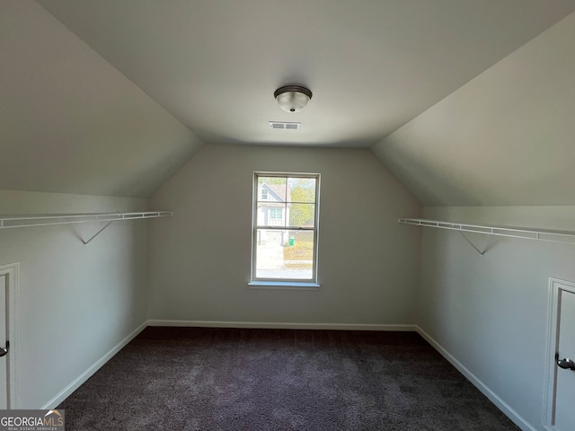 bonus room with lofted ceiling and dark colored carpet