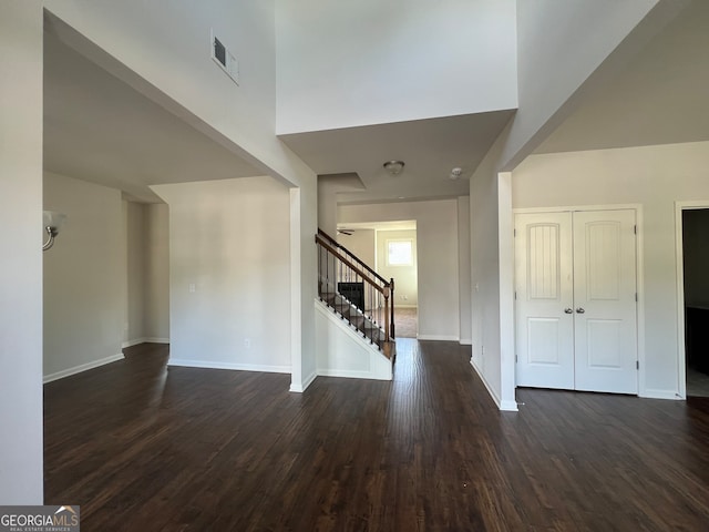 entrance foyer with dark wood-type flooring and a towering ceiling