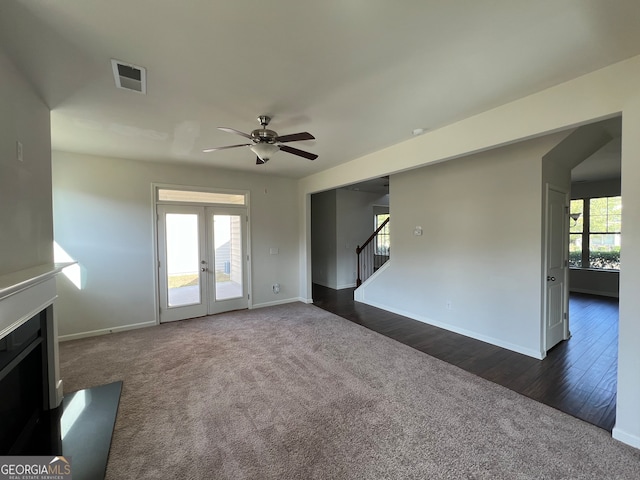 unfurnished living room featuring dark wood-type flooring, ceiling fan, plenty of natural light, and french doors