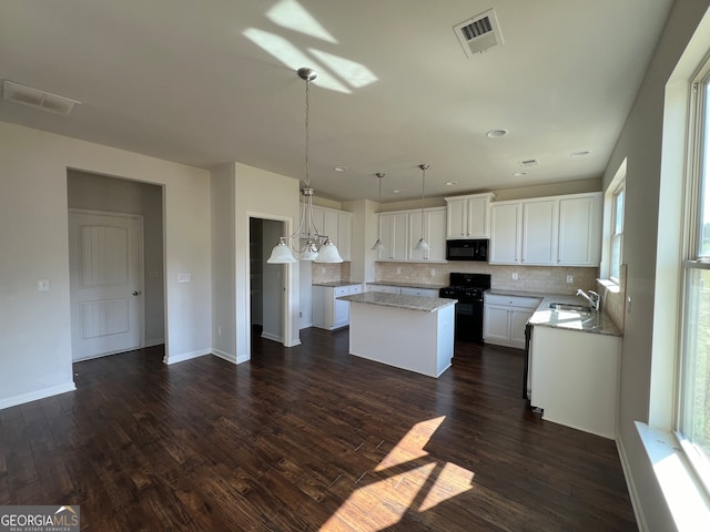 kitchen with dark hardwood / wood-style flooring, white cabinets, black appliances, sink, and tasteful backsplash