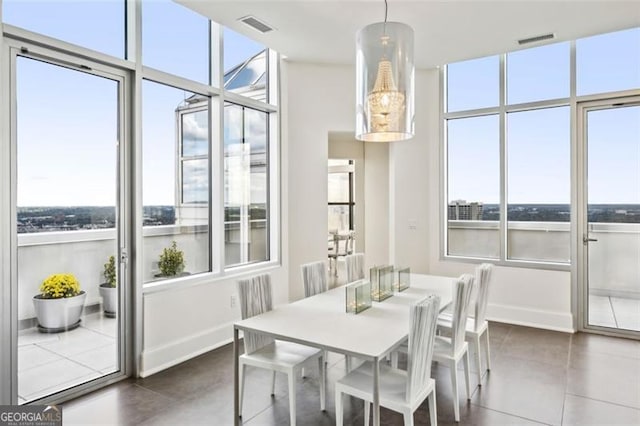 dining space featuring dark tile patterned flooring and a wealth of natural light