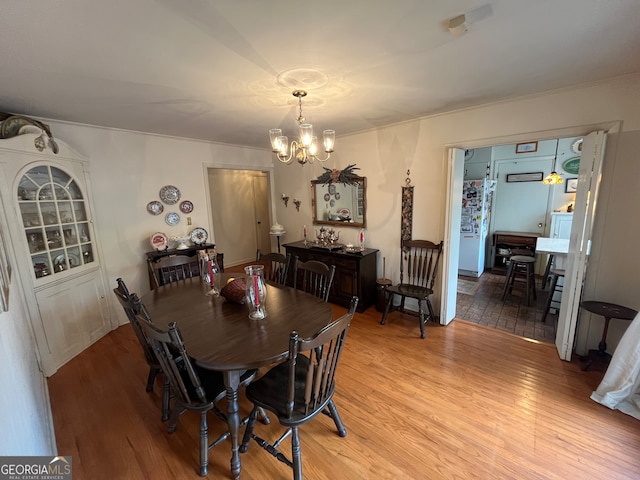 dining area featuring an inviting chandelier and light wood-type flooring