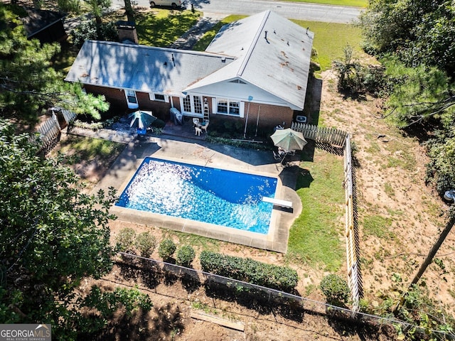 view of swimming pool featuring a diving board and a patio area