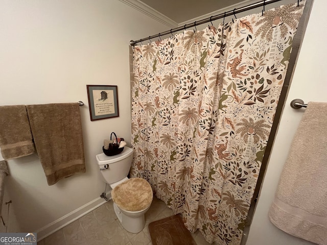 bathroom with tile patterned flooring, ornamental molding, and toilet