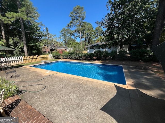 view of pool featuring a diving board and a patio area