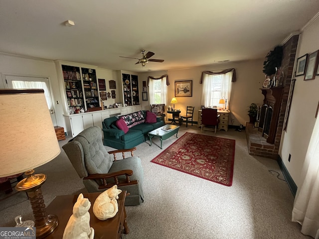 carpeted living room with a fireplace, crown molding, and ceiling fan