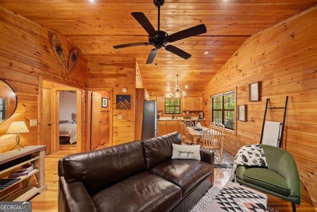 living room featuring wood walls, light hardwood / wood-style floors, wood ceiling, and vaulted ceiling