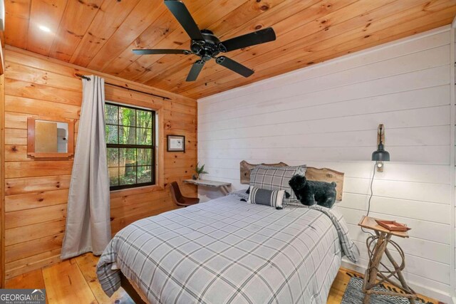 bedroom featuring wooden walls, ceiling fan, wood ceiling, and light hardwood / wood-style floors