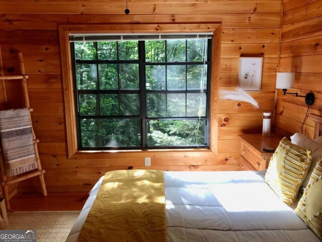 bedroom featuring wood walls and multiple windows